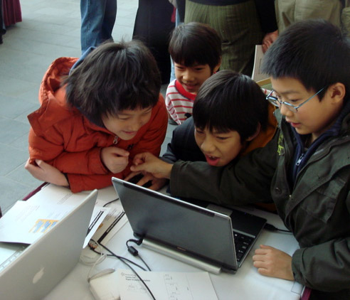 Group of excited kids focusing on a game that one of them created in the 2009 Math Camp
