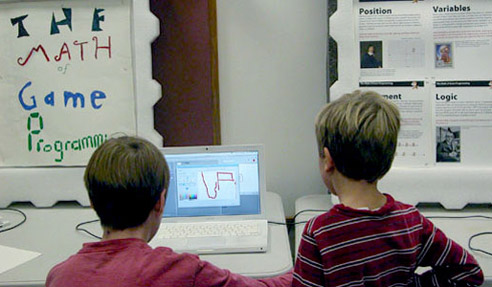 Two kids programming a game